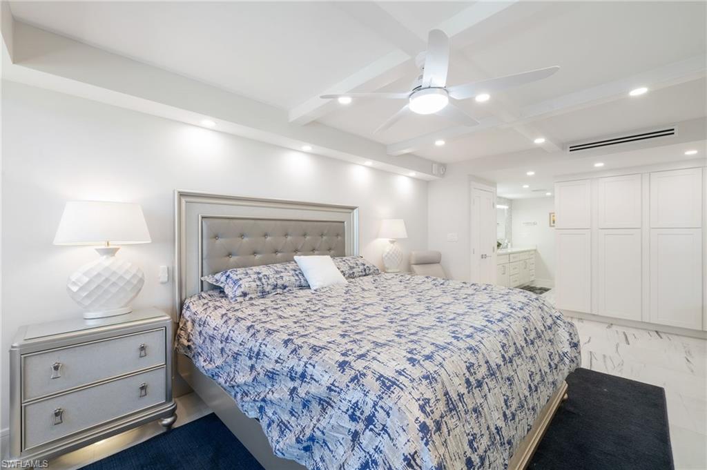Bedroom with ceiling fan, beamed ceiling, and connected bathroom