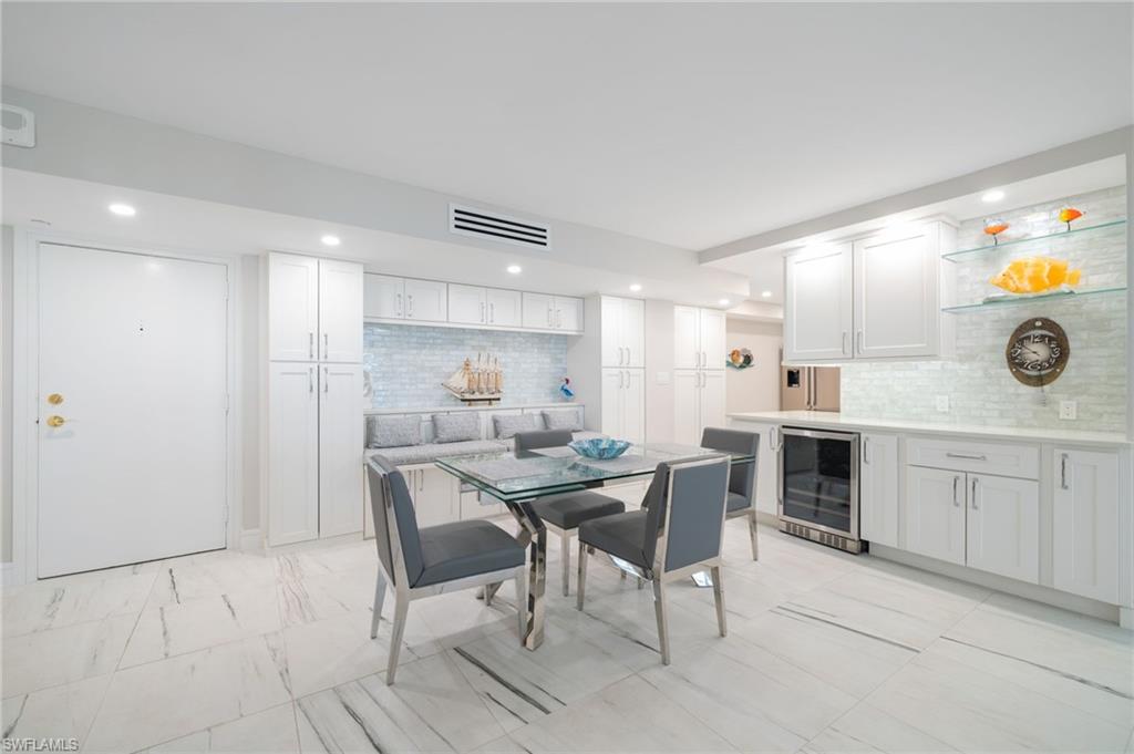 Dining space featuring light tile patterned flooring and beverage cooler