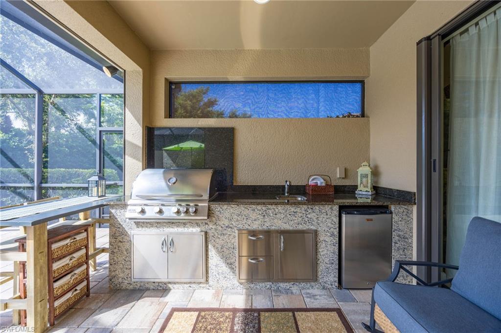 Outdoor gourmet kitchen with high-end grill, stone prep counters, and integrated dining area perfect for entertaining.