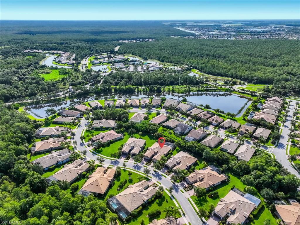 Aerial perspective showcasing residential properties amidst lush green landscapes and water features
