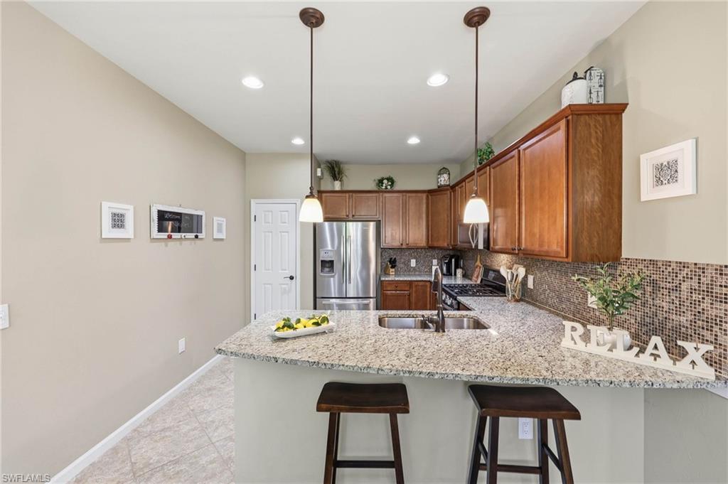Modern kitchen featuring a spacious island, premium stainless steel appliances, and located in a desirable natural gas community.