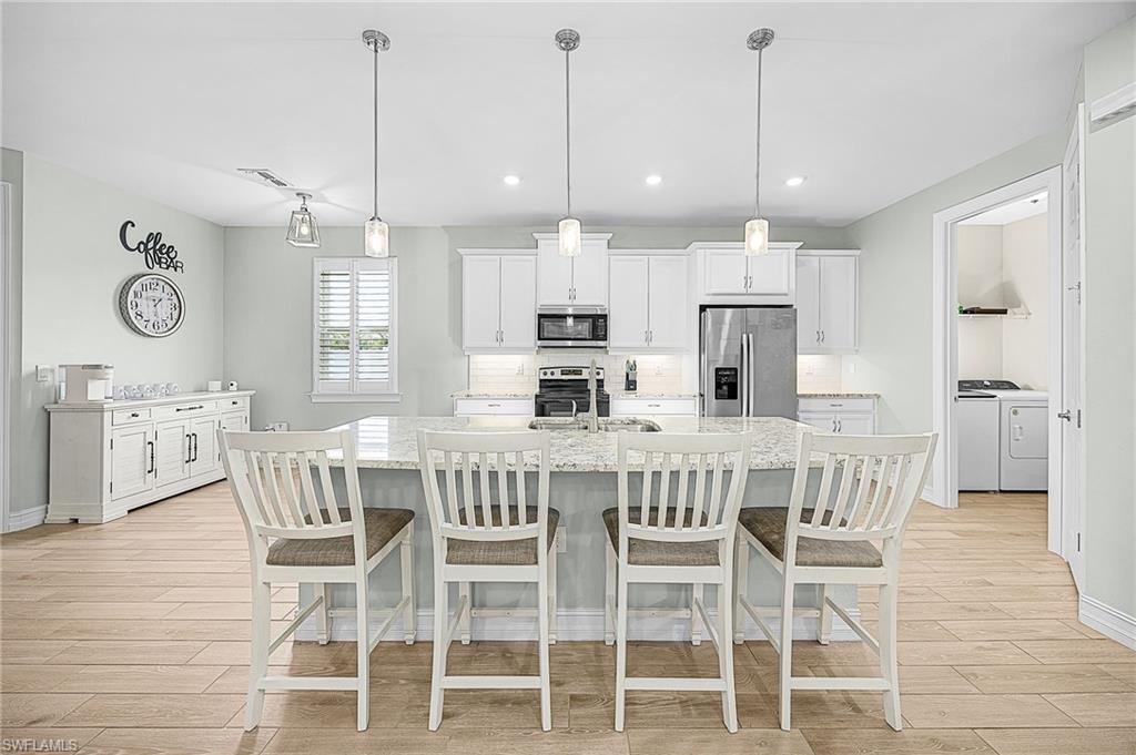 Oversized kitchen island with abundant seating and prep space, ideal for hosting gatherings, casual dining, or meal preparation in this chef-inspired kitchen.
