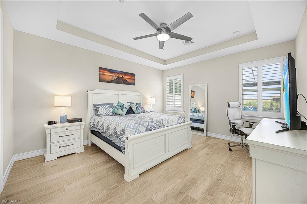 Spacious primary suite with tray ceiling, abundant natural light —offering a true retreat within this Cape Coral pool home.