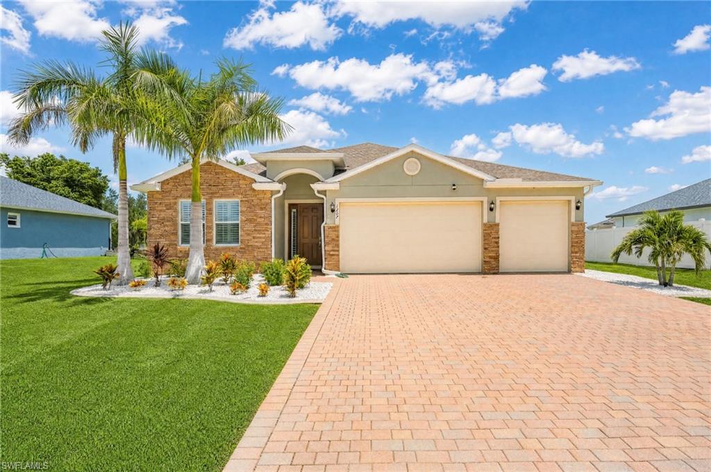 Welcome home to this oversized Cape Coral homesite featuring a wide paver driveway, spacious 3-car garage, lush tropical landscaping, and ample parking—ideal for families, guests, or multi-vehicle households.