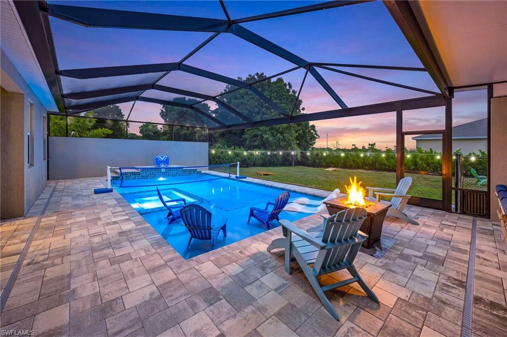 Resort-style outdoor living begins here, showcasing one of the most impressive backyard setups in Northwest Cape Coral.  Pool and spa illuminated for unforgettable Florida evenings, creating a stunning nighttime ambiance perfect for entertaining.  Ai Dusk Conversion.