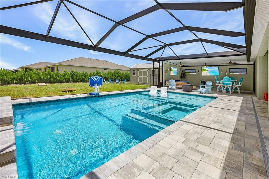 Expansive sun shelf with in-water loungers and a raised waterfall feature, creating a resort-style pool experience right at home.  The oversized spa creates the perfect space to relax on those 75 degree January evenings in SWFL.