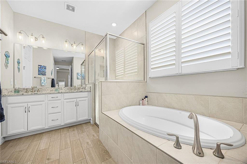 Luxurious primary bathroom featuring dual vanities, soaking tub, and a walk-through shower—designed for comfort, relaxation, and spa-like living.