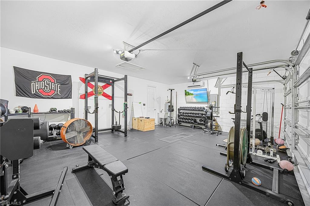 Oversized 3-car garage featuring an 18,000 BTU smart mini-split heating and cooling system—perfect for a workshop, gym, or climate-controlled storage.  Easy setup for a fun Airbnb game room with AC already in place.  Clean and ready for you!