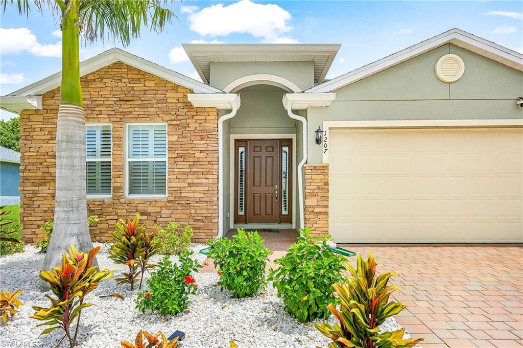 Tropical landscaping designed for beauty and low maintenance, enhancing curb appeal and outdoor enjoyment.  Newly installed custom concrete curbing and white marble stone provides low maintenance with an upgraded luxurious look.  That white stone is expensive.