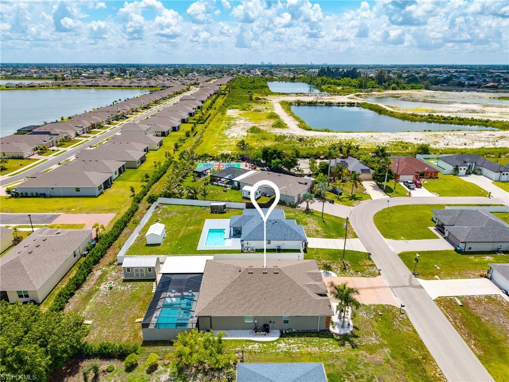 Bird’s-eye aerial view showcasing the oversized homesite, expansive outdoor living areas, and overall layout of this Cape Coral property.