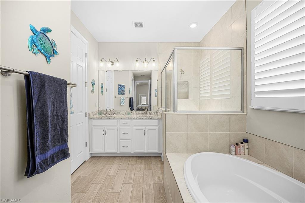 Large walk-in shower with modern tile finishes, dual access, and a spacious layout—perfect for a luxury primary suite experience.  Walk in closet and separate water closet.