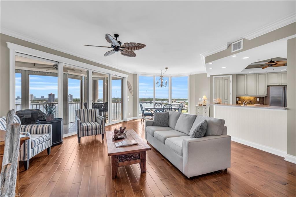 Spacious living room with kitchen to the right and views of bay and so much natural light.
