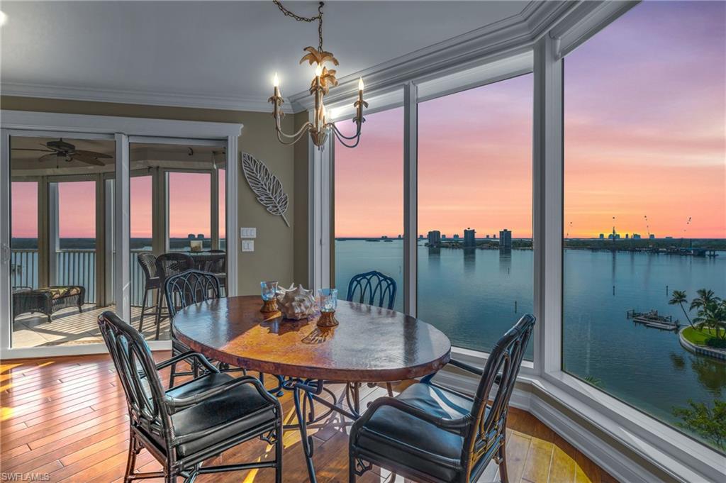 Dining room featuring crown molding, a water view, hardwood / wood-style floors, and a wealth of natural light