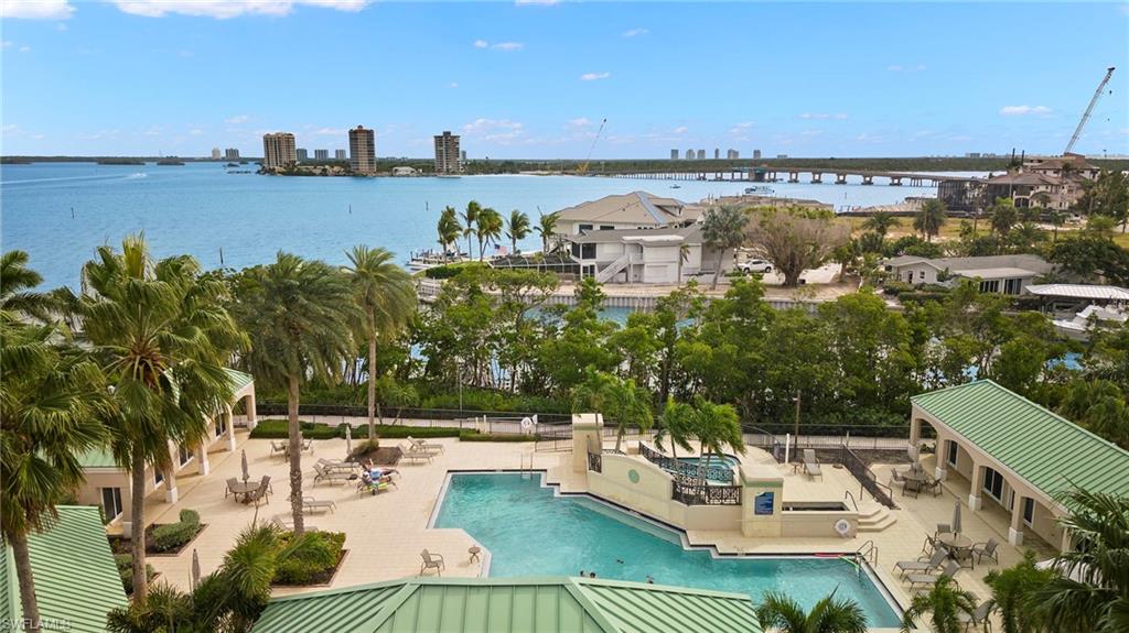 View of swimming pool with a water view and a patio area, with the spa area just in view
