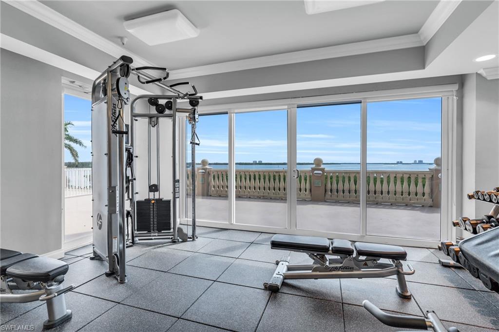 Exercise room with ornamental molding and a water view