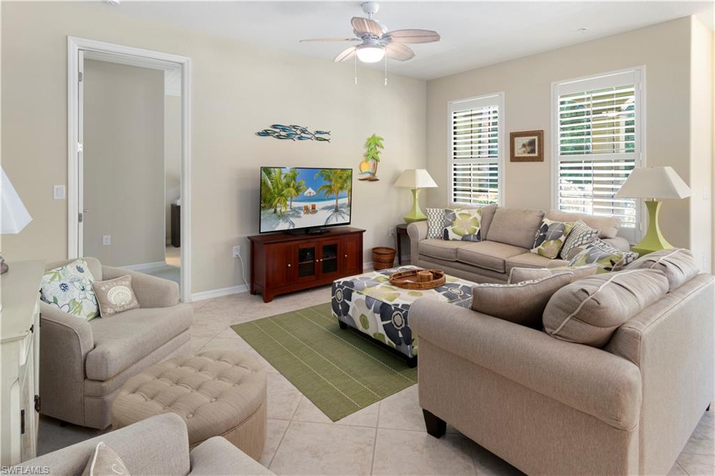 Living room with ceiling fan and light tile patterned flooring