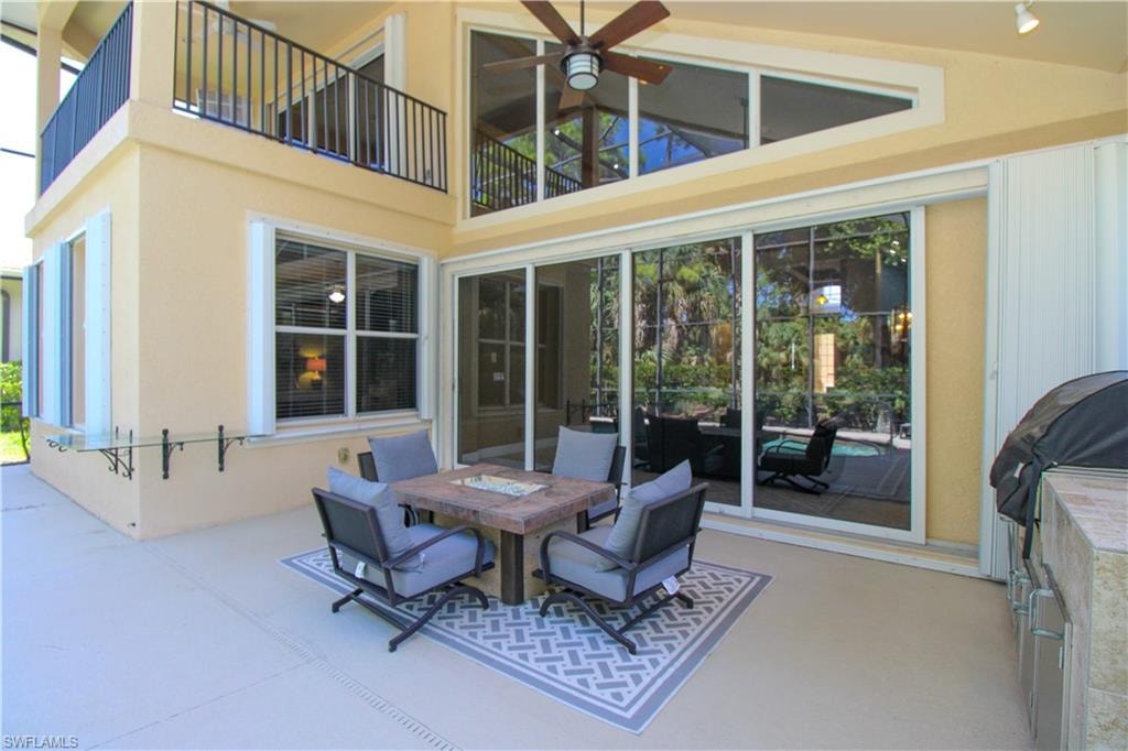 View of patio featuring grilling area, a balcony, and ceiling fan
