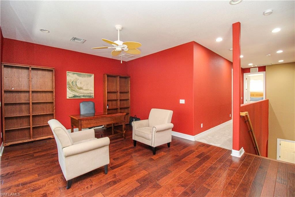 Sitting room with wood-type flooring and ceiling fan