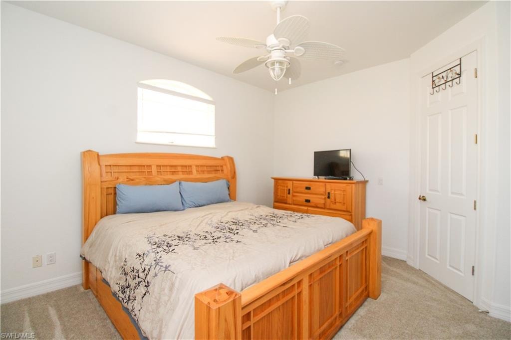 Carpeted bedroom featuring ceiling fan