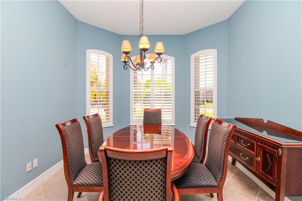 Dining space featuring light tile patterned floors and a chandelier