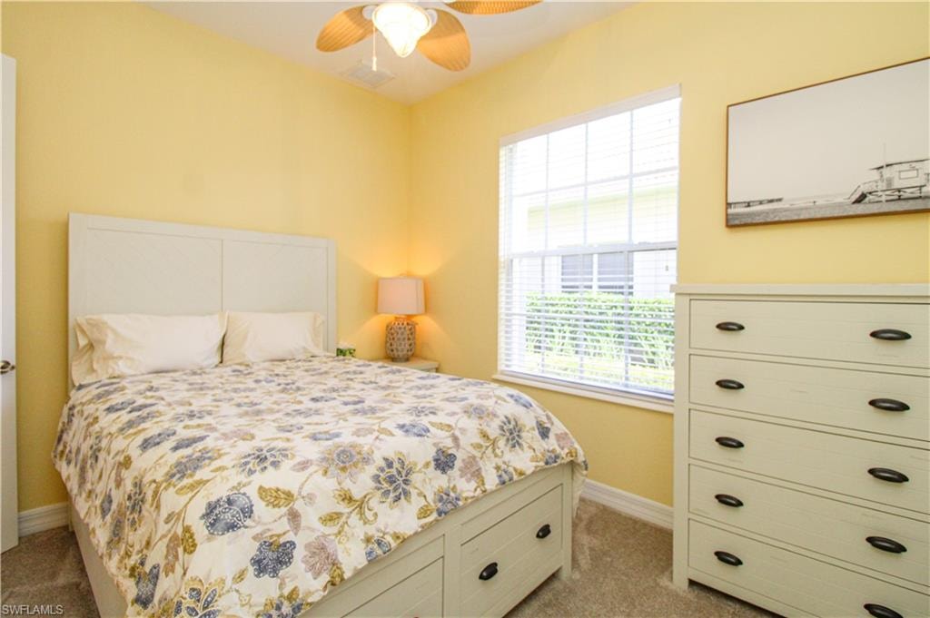 Bedroom with light colored carpet and ceiling fan