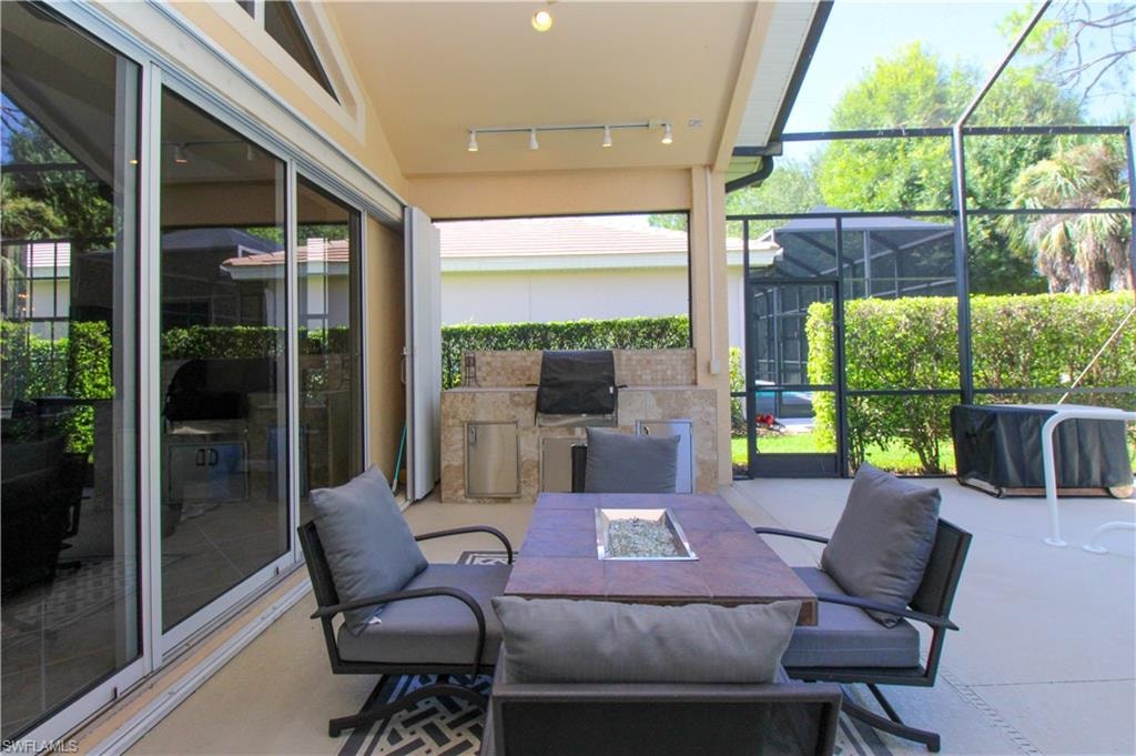 Sunroom featuring track lighting and lofted ceiling