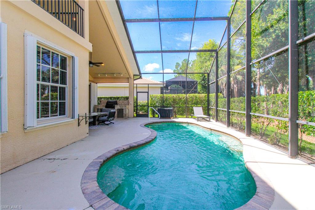View of pool with a patio, ceiling fan, and glass enclosure