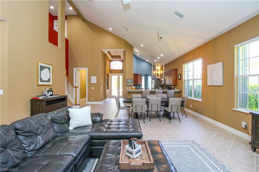 Tiled living room featuring an inviting chandelier and high vaulted ceiling