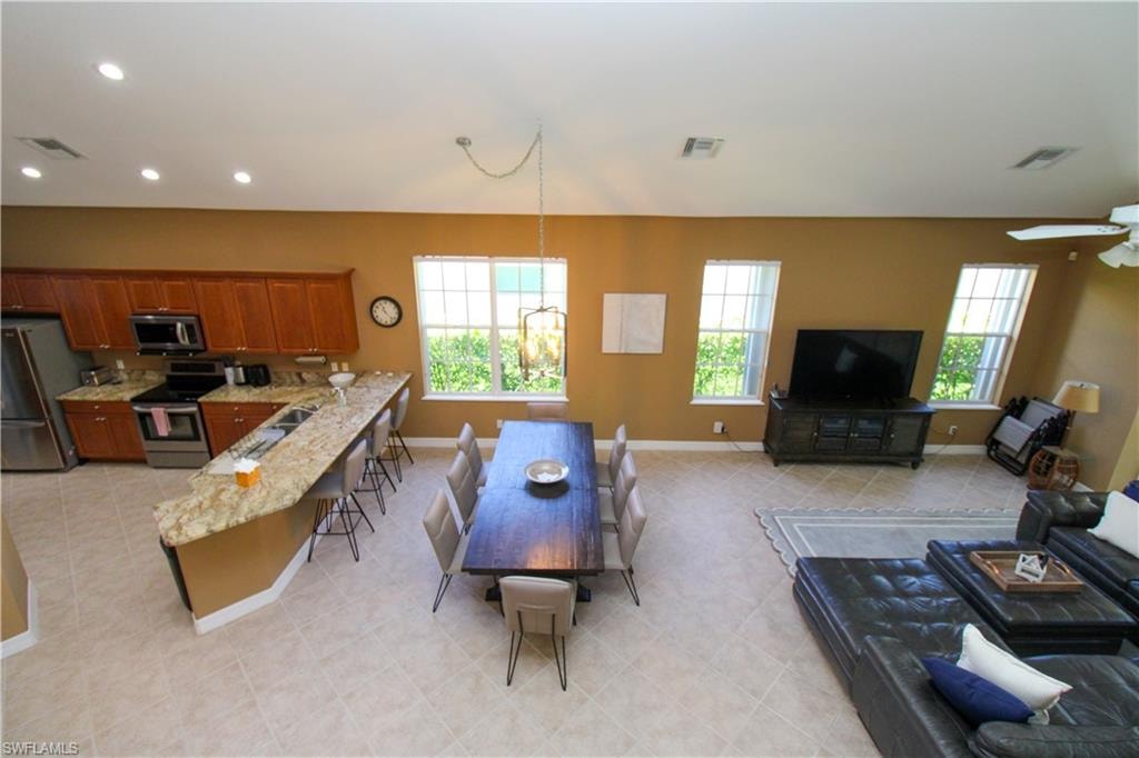 Living room featuring sink, light tile patterned floors, and ceiling fan