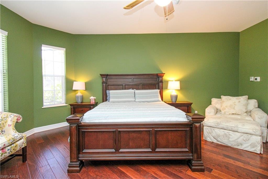 Bedroom with ceiling fan and dark hardwood / wood-style floors