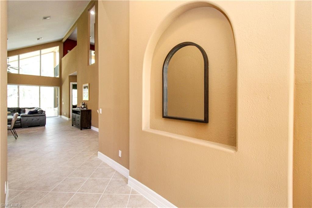 Corridor with tile patterned floors and high vaulted ceiling