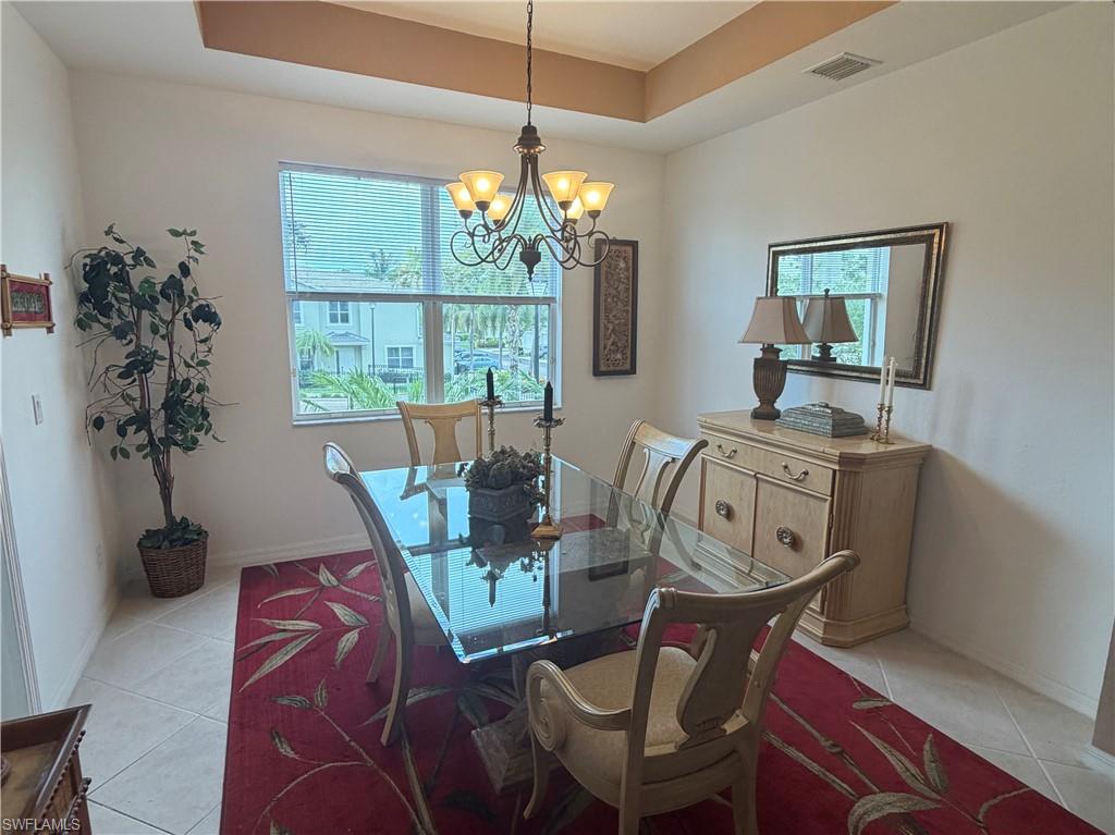 Dining area featuring a coffered ceiling, tiled flooring, and a multi-pane window