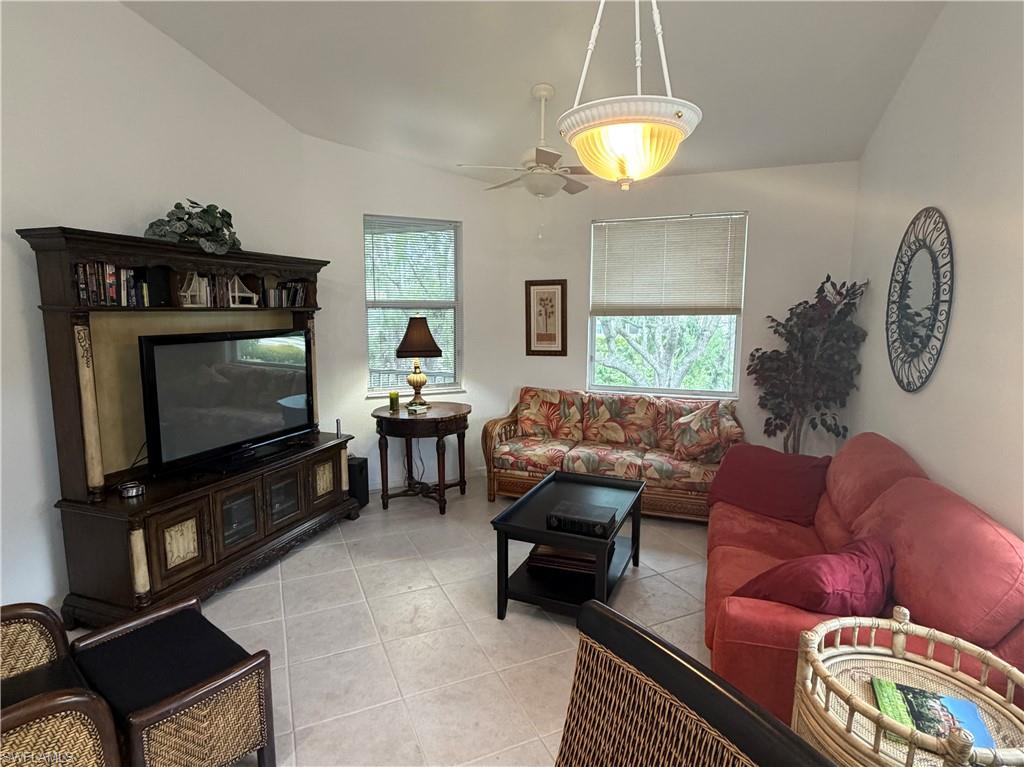 Spacious living area featuring vaulted ceilings, a ceiling fan, and recessed lighting