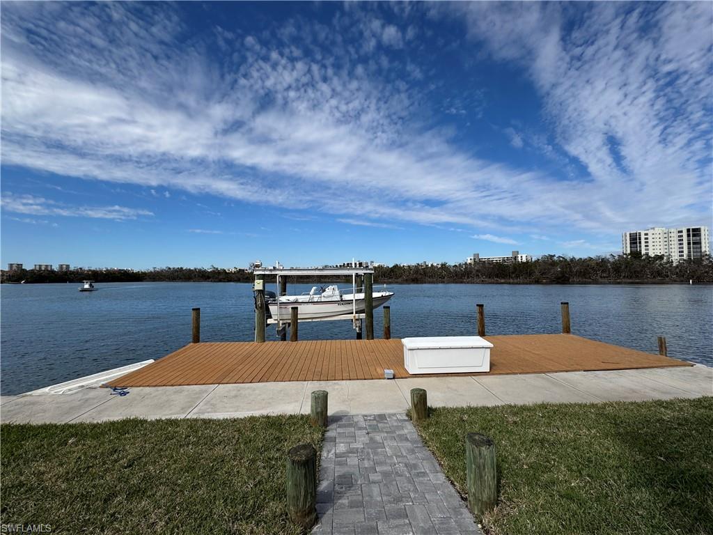View of dock featuring a water view and a lawn