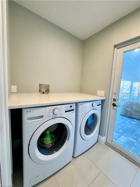 Laundry area with independent washer and dryer and light tile patterned floors