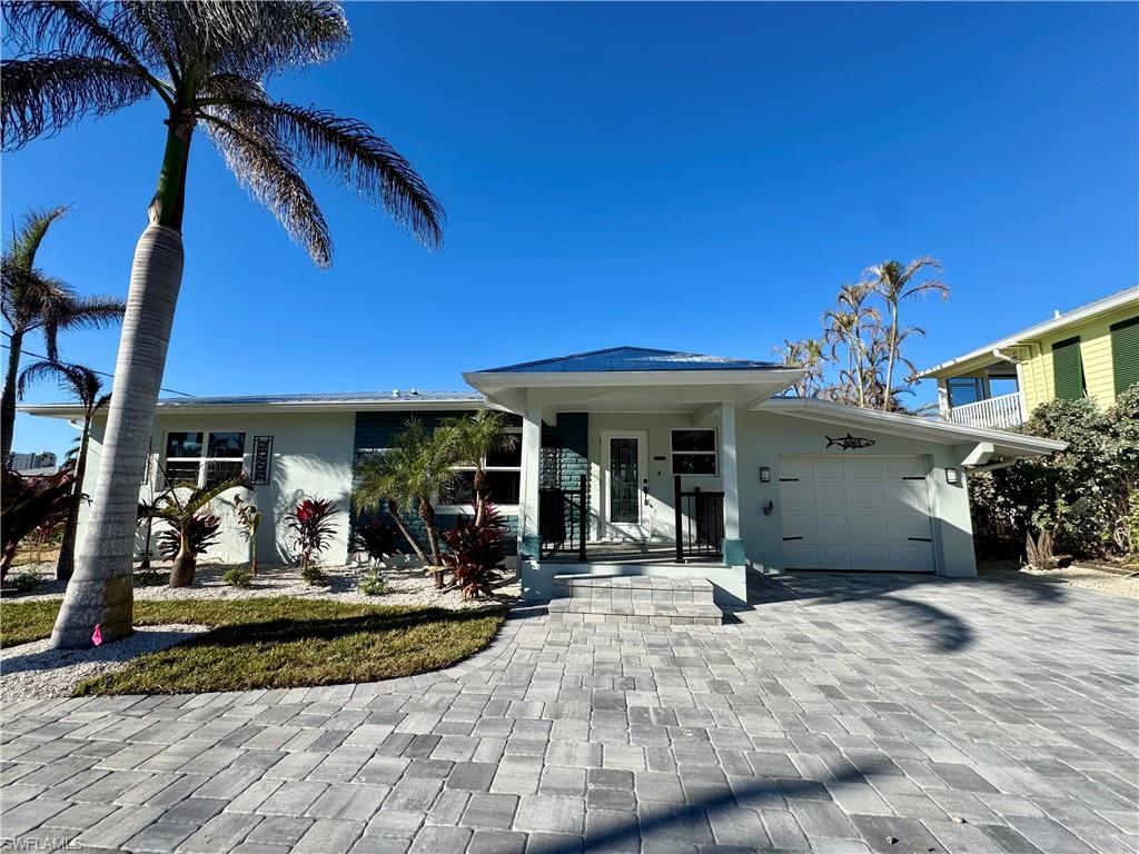 View of front of property with a porch and a garage