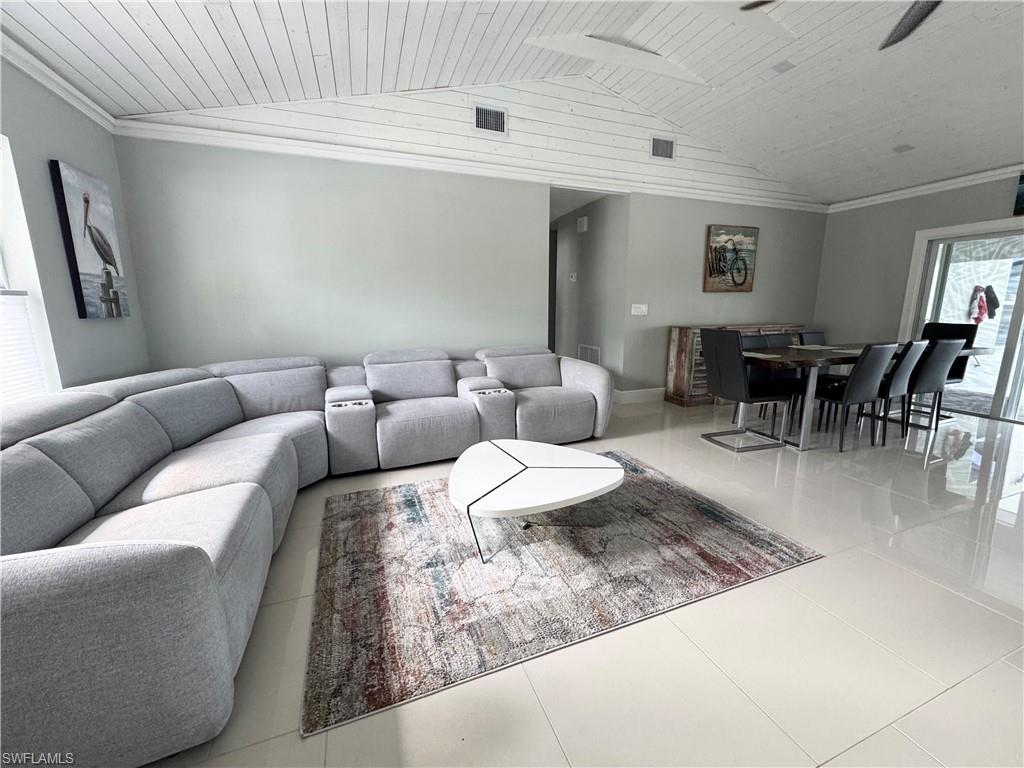 Living room featuring wood ceiling, tile patterned flooring, and vaulted ceiling