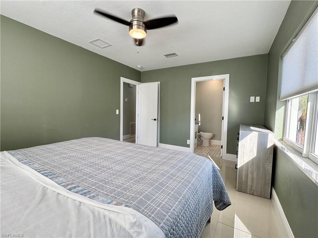 Tiled bedroom with ceiling fan and ensuite bathroom