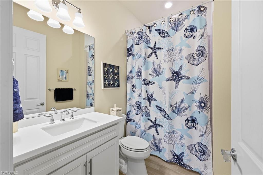 Bathroom #2 featuring a white vanity with tub and shower