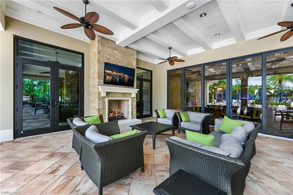 Covered outdoor community area featuring a stone accent wall with a fireplace