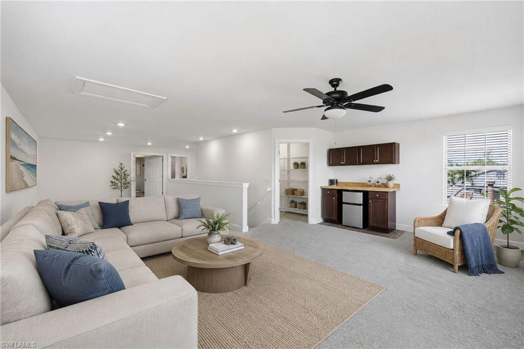 VIRTUAL STAGED - bonus room featuring recessed lighting, a ceiling fan, a built-in bar with cabinetry and a beverage cooler, and carpet flooring