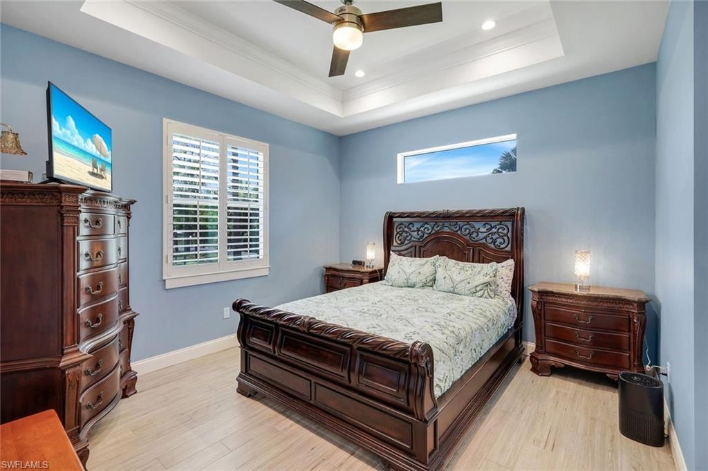 Room featuring a tray ceiling with recessed lighting and a ceiling fan