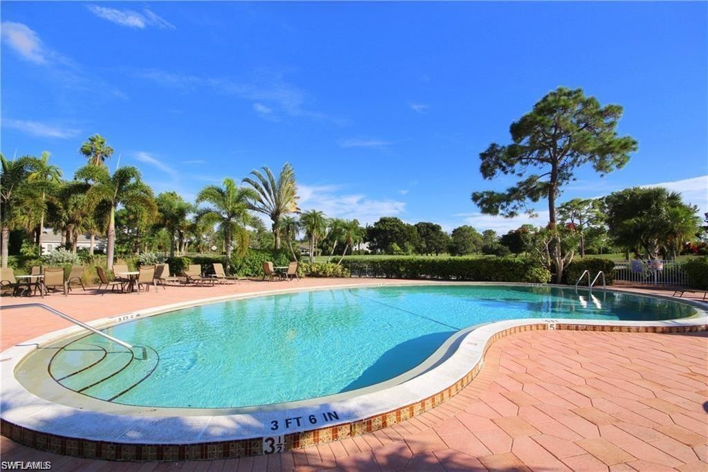 Community pool with a patio and fence