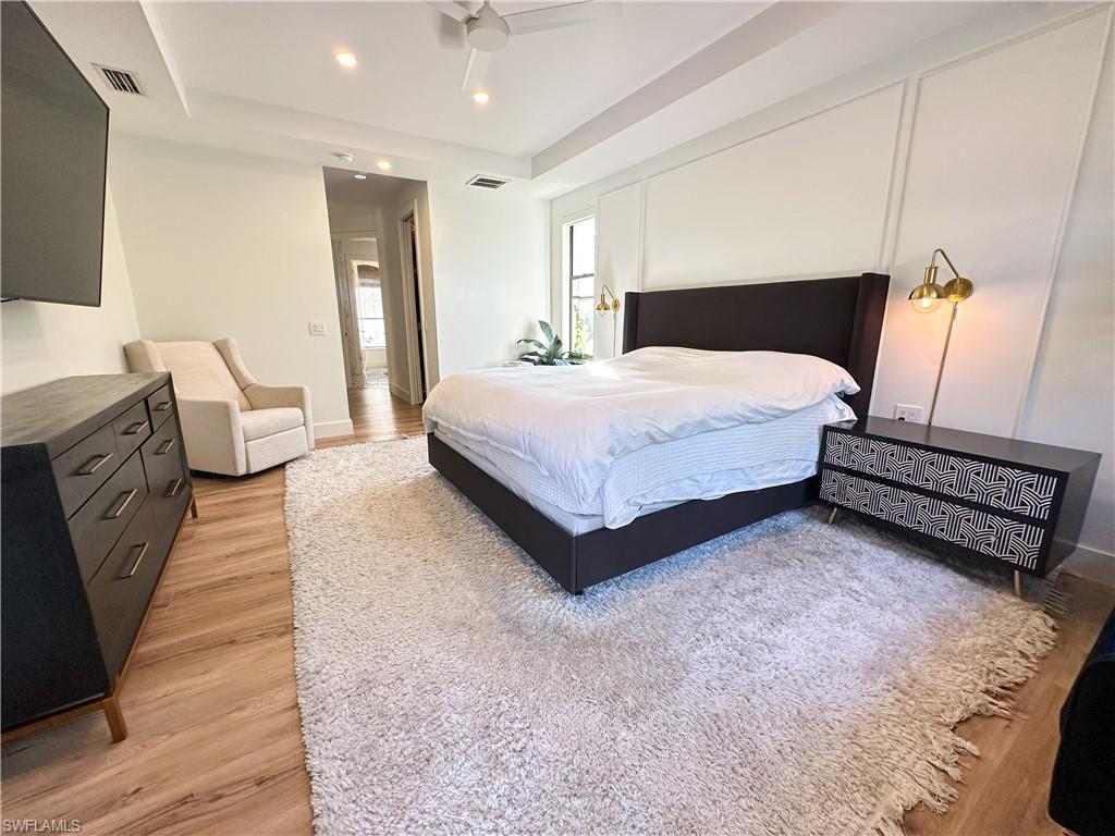 Bedroom featuring a raised ceiling and light hardwood / wood-style floors