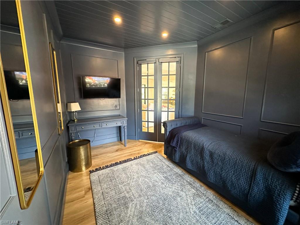 Bedroom with wood ceiling and light hardwood / wood-style floors