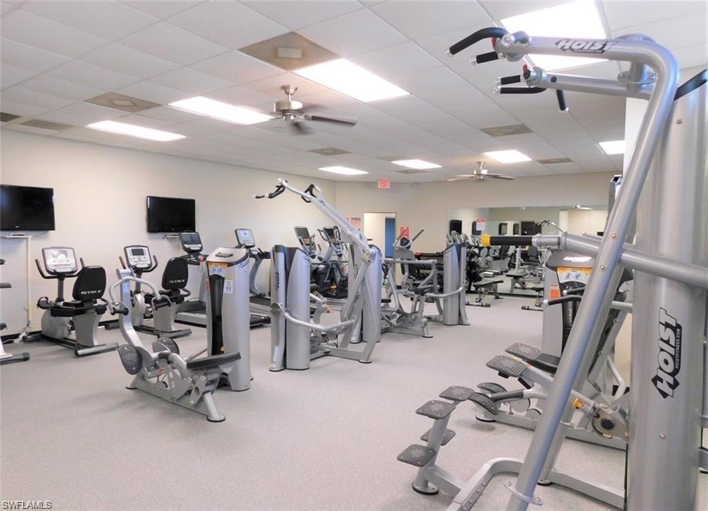Exercise room with a paneled ceiling and a ceiling fan