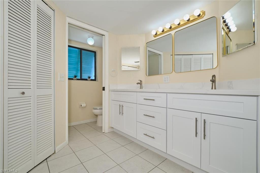 Dual vanity with white cabinetry, integrated sinks, and brushed nickel faucets