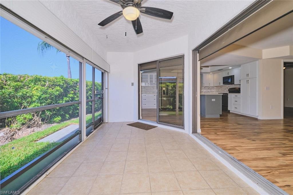 Screened patio featuring tile flooring and a ceiling fan