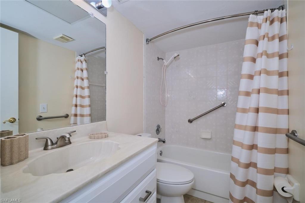 Bathroom featuring a white vanity with an integrated sink, brushed nickel faucet, and a large mirror