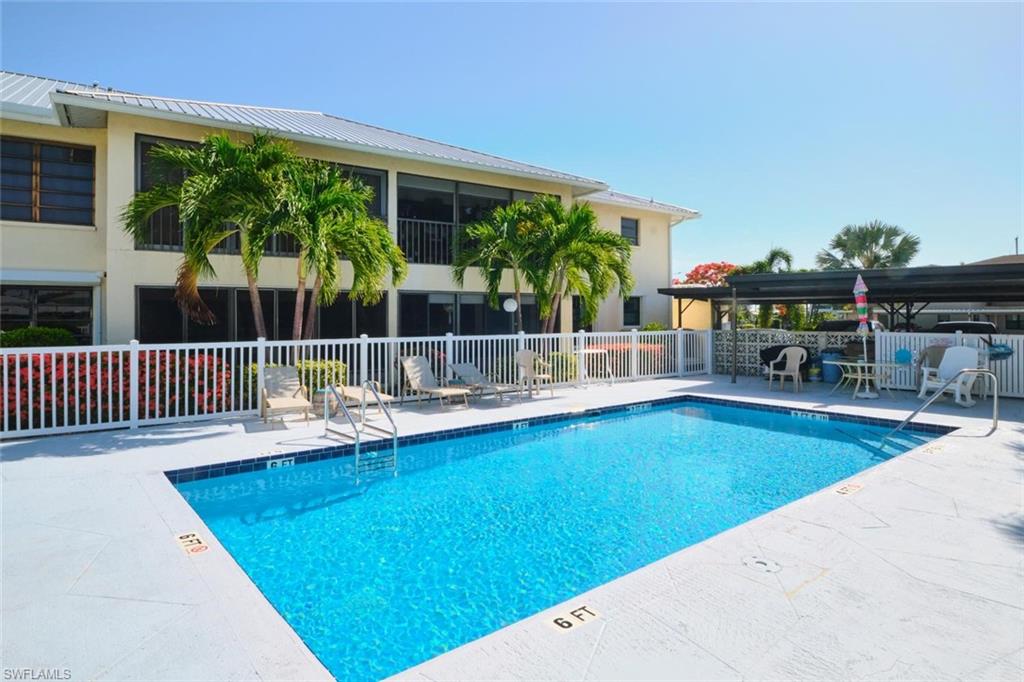 Rectangular swimming pool with integrated steps and a white perimeter fence